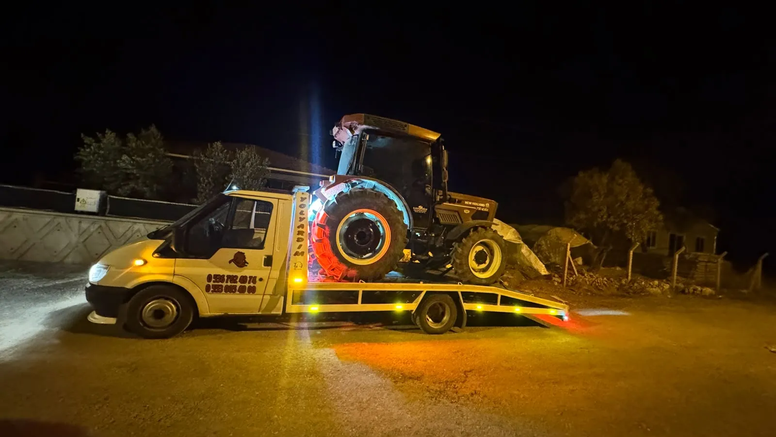 Gece, kasasında New Holland traktör taşıyan çekici
